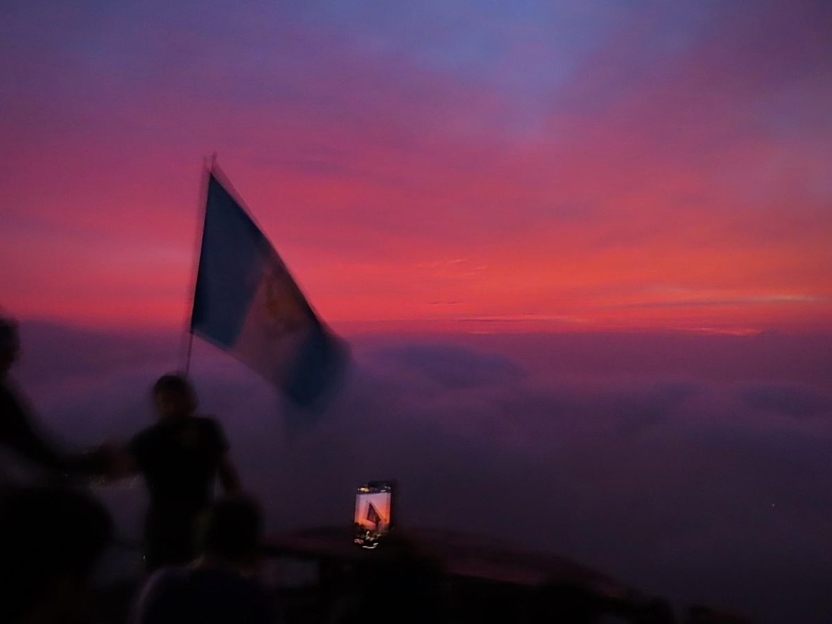 A hiker takes a photo of the Guatemalan flag at the top of the Indian Nose hike, as photographed on March 15, 2024. (Hustler Multimedia/Isabella Bautista)